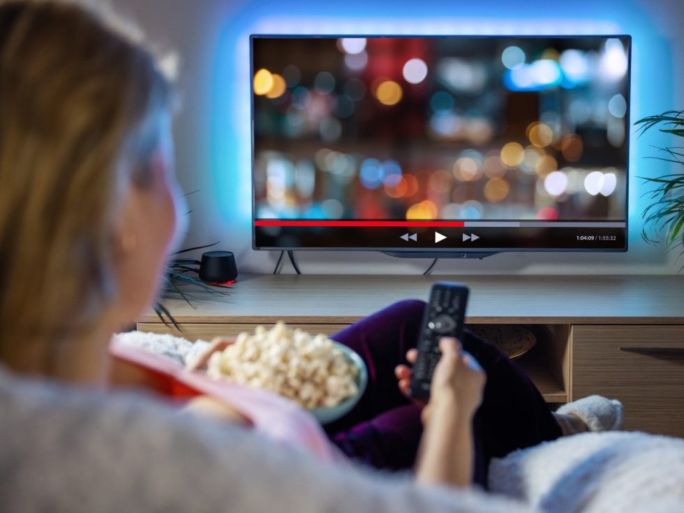 Persona viendo series en televisión para aprender inglés de forma divertida y mejorar listening y vocabulario.