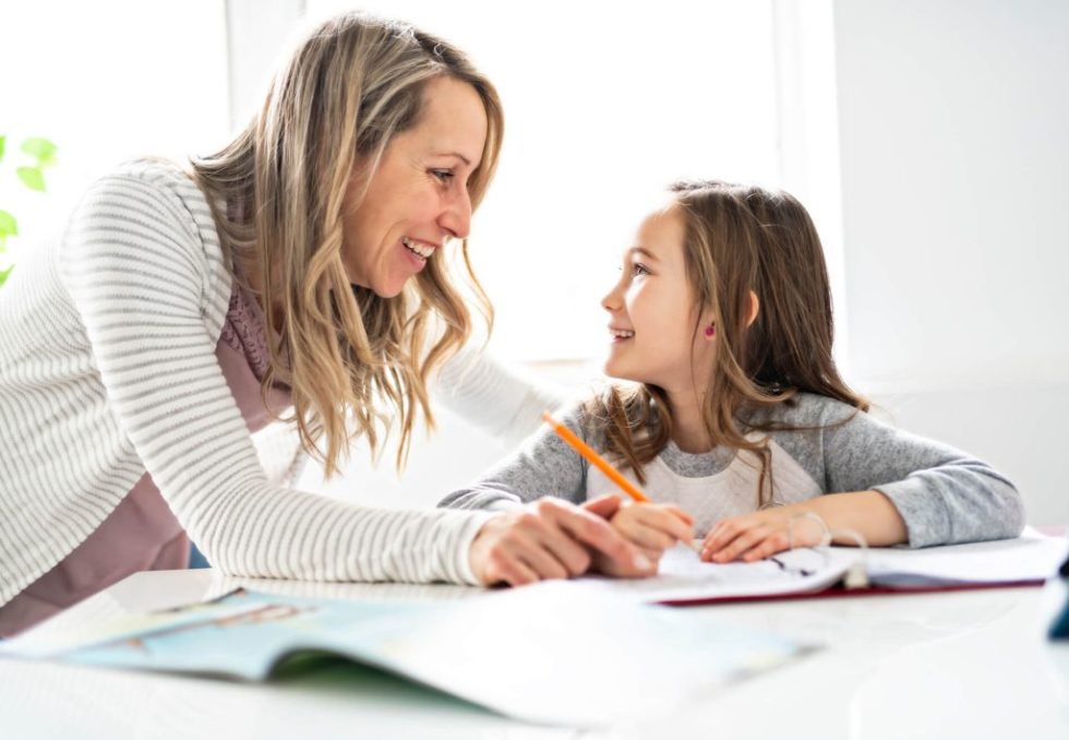 Madre ayudando a su hija a organizar el estudio para los exámenes Cambridge Starters, Movers y Flyers.